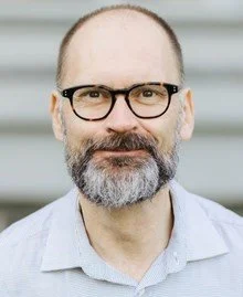 Man with glasses and beard smiling