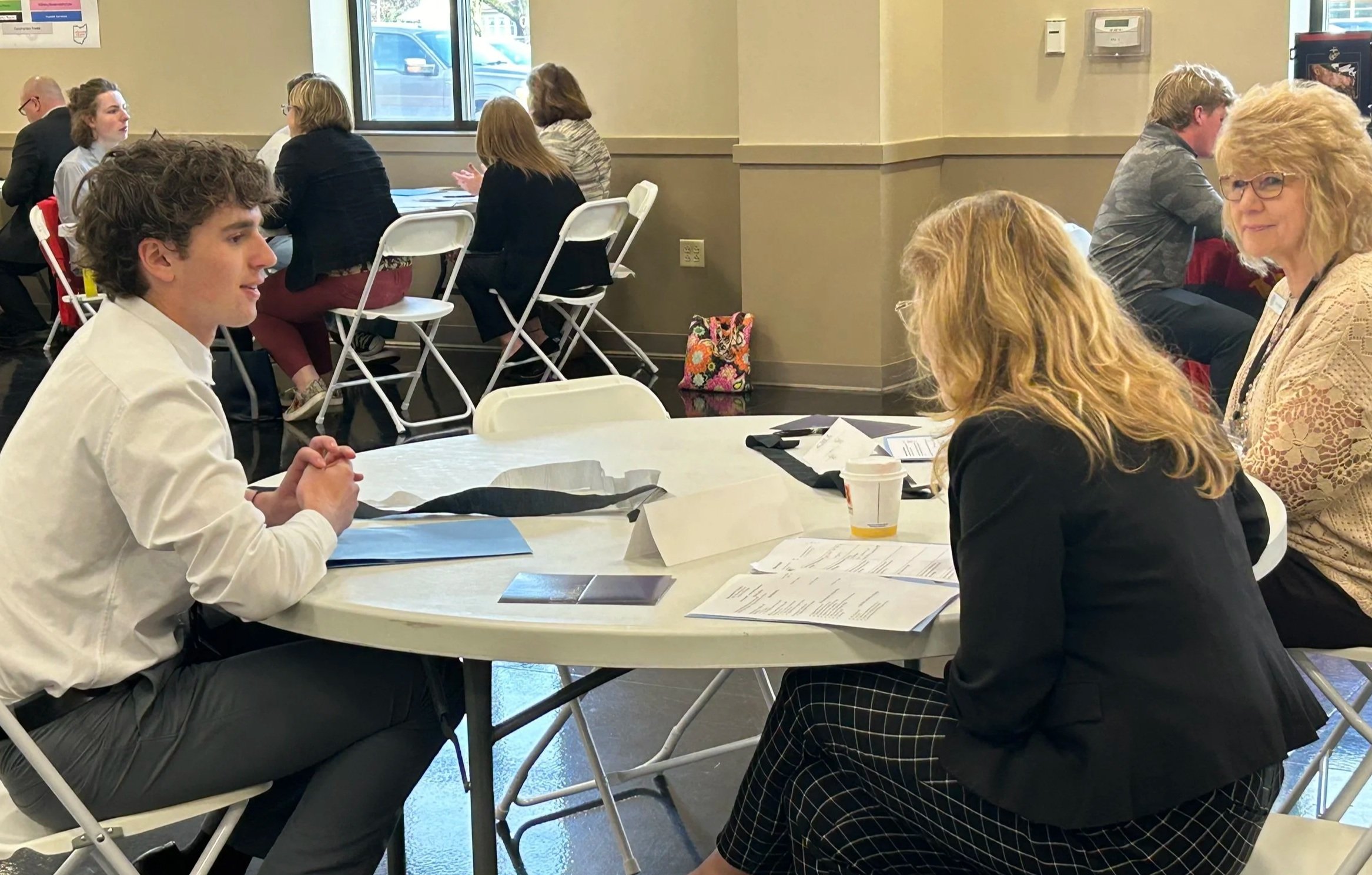 High school student interviewing with business professional.