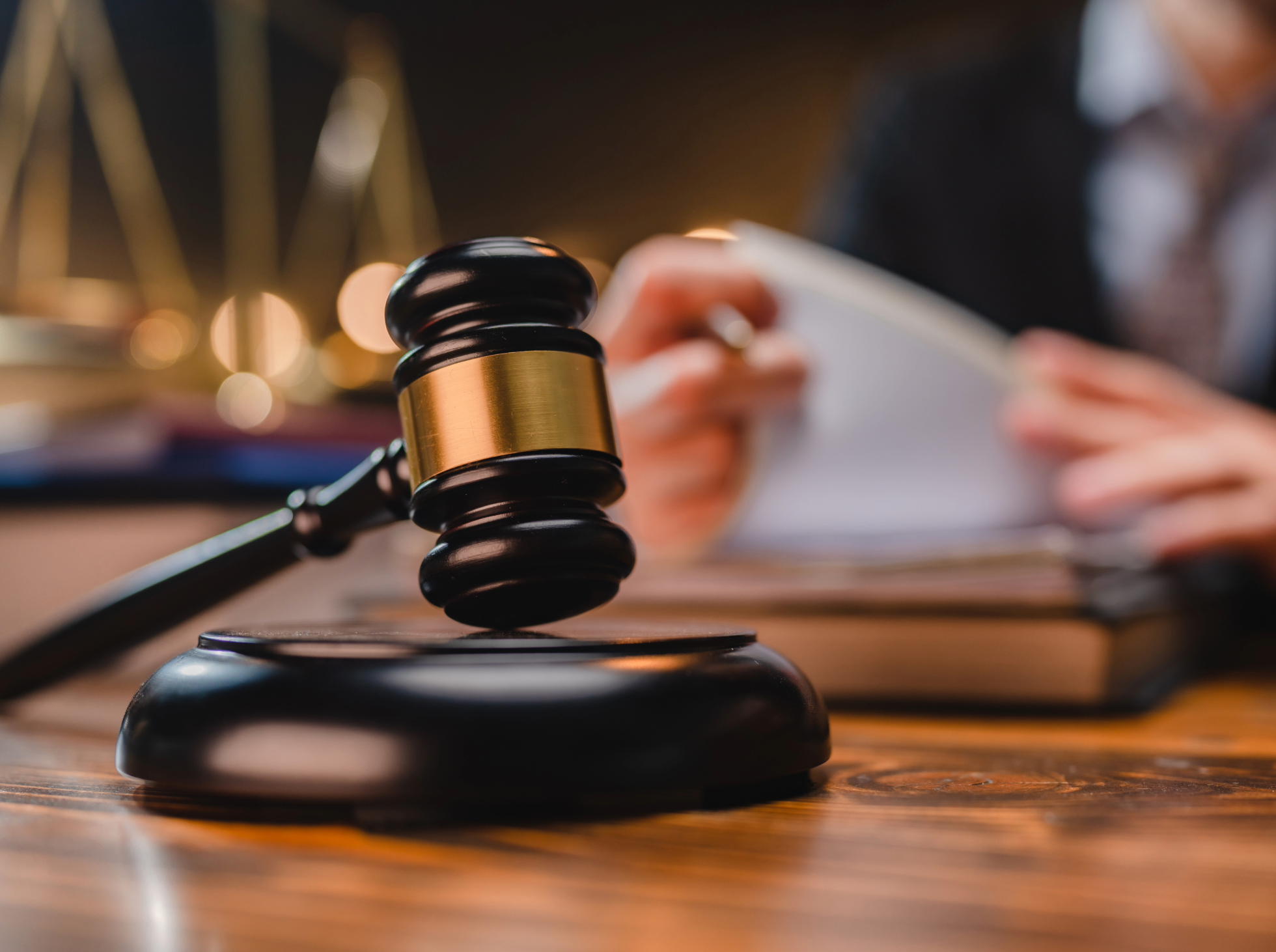A judge's gavel resting on a wooden table in a courtroom.