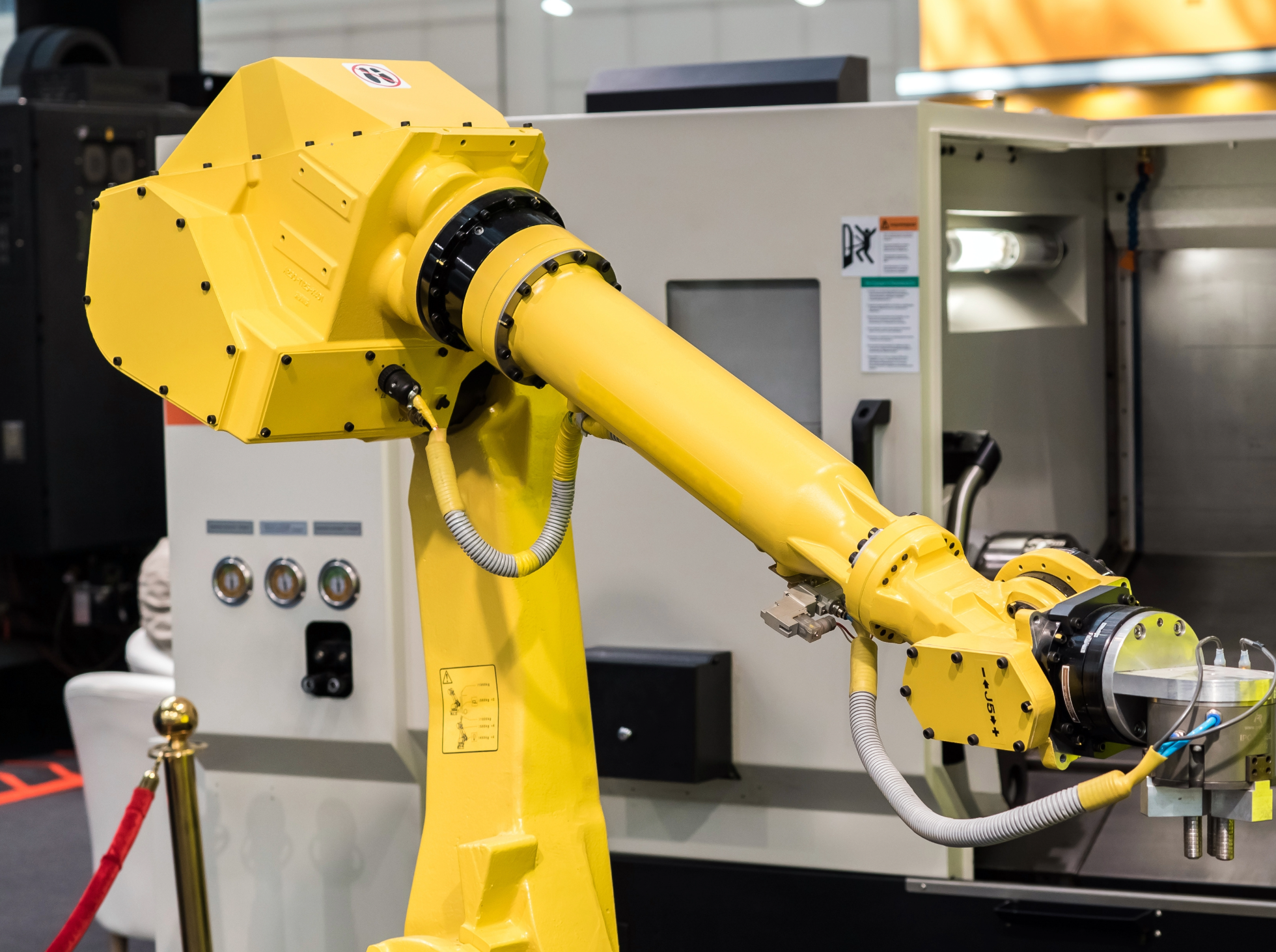 Yellow industrial robotic arm in a manufacturing facility.