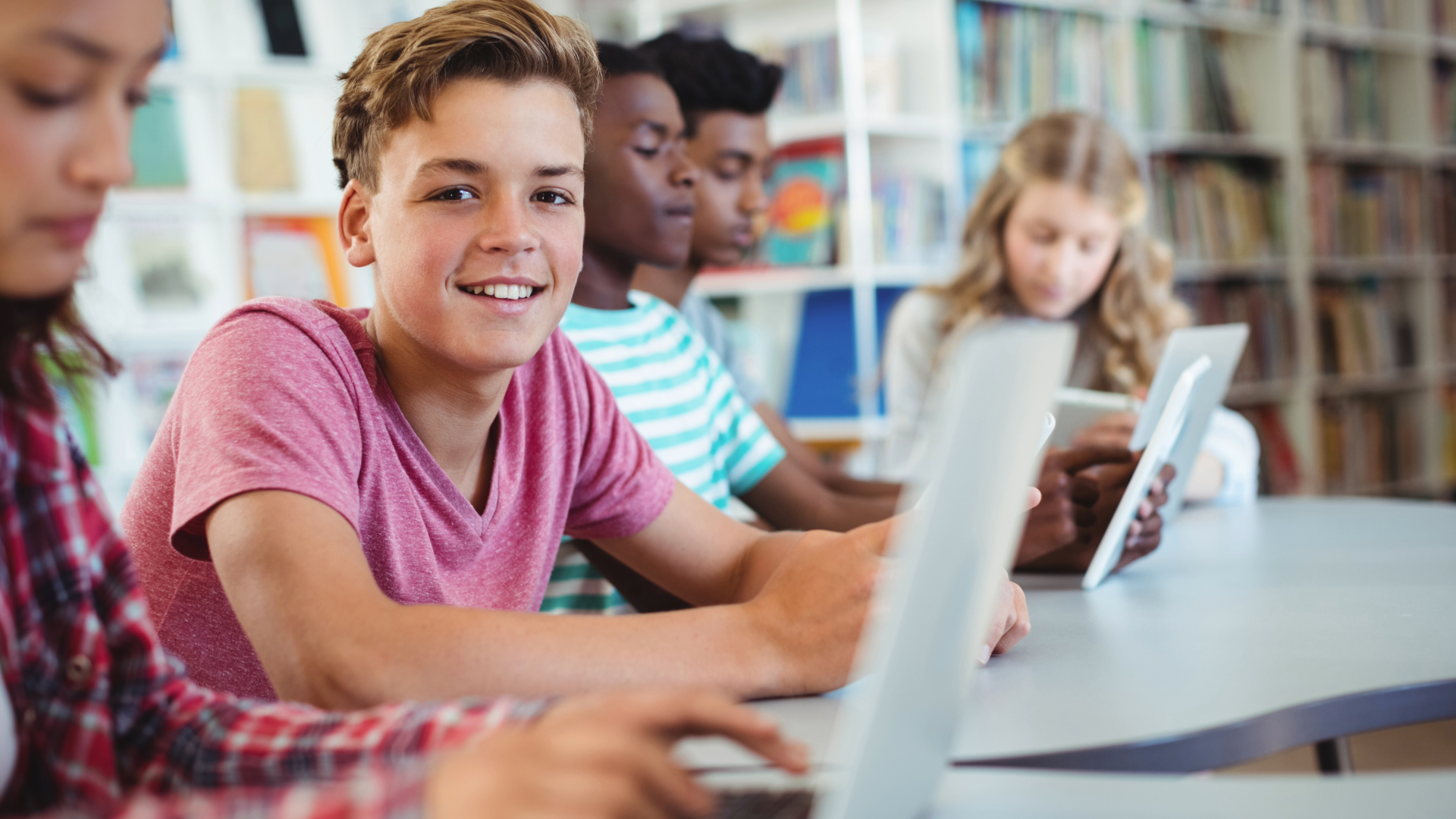 Middle school students learning on digital devices.