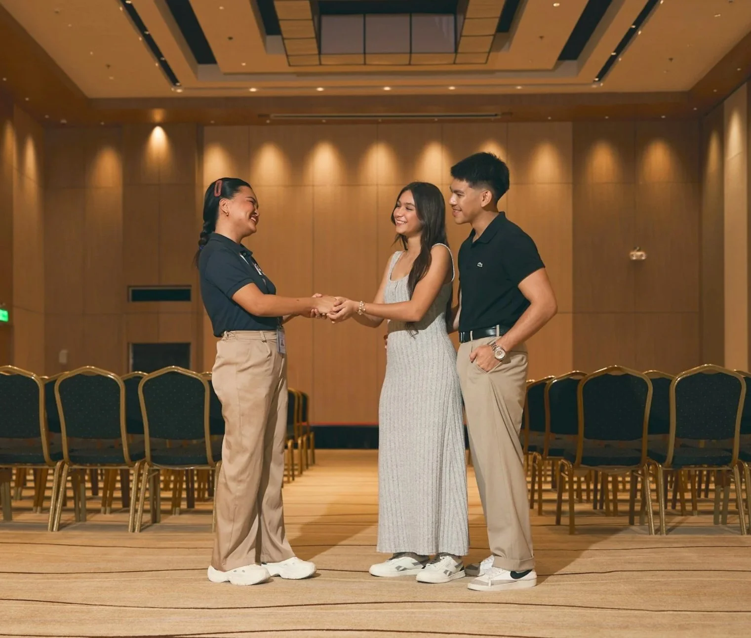 Male and female getting introduced to event planner in ballroom.