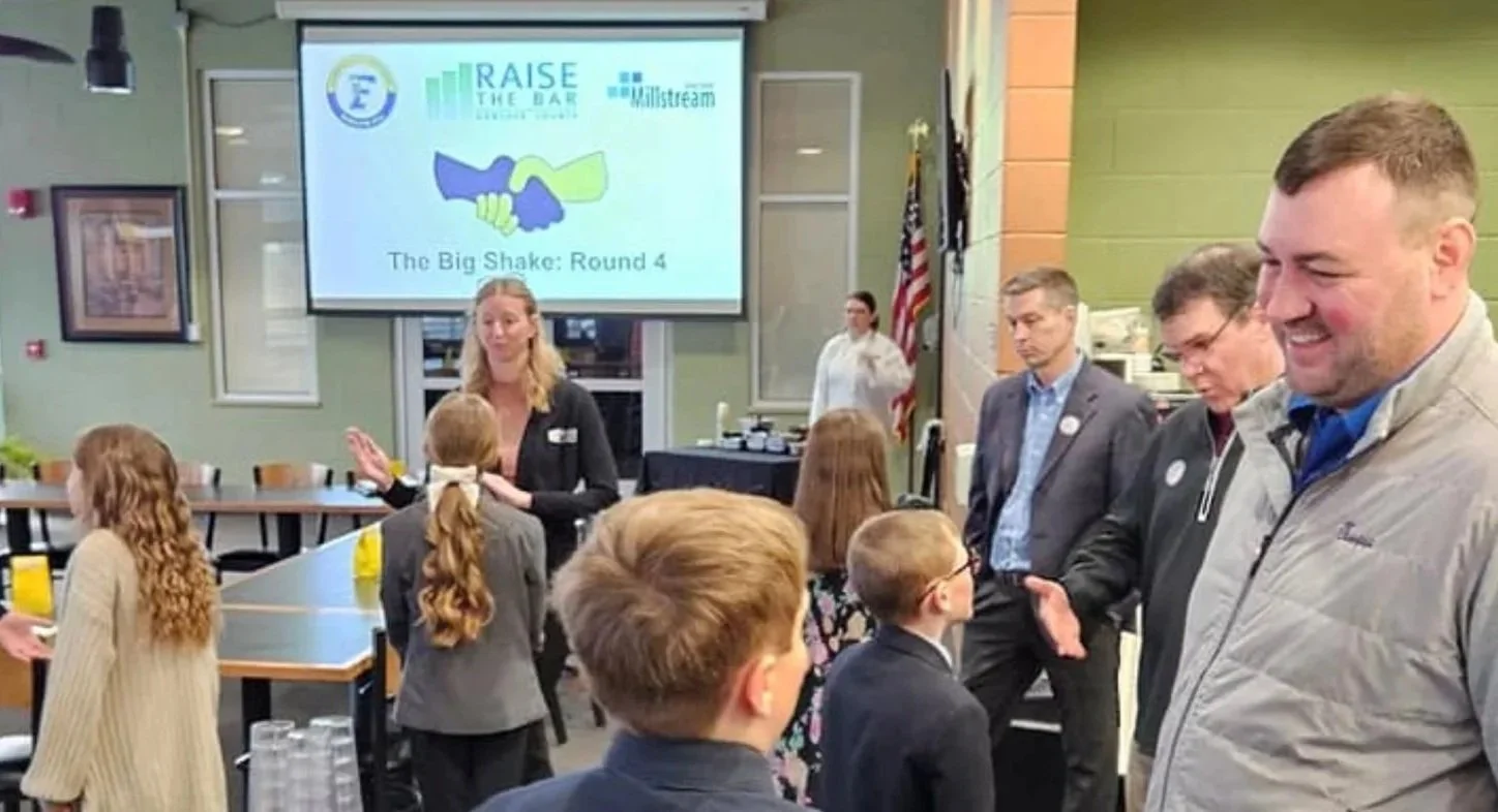 BIG Shake Round 4 Raise the Bar board members and staff with elementary students.