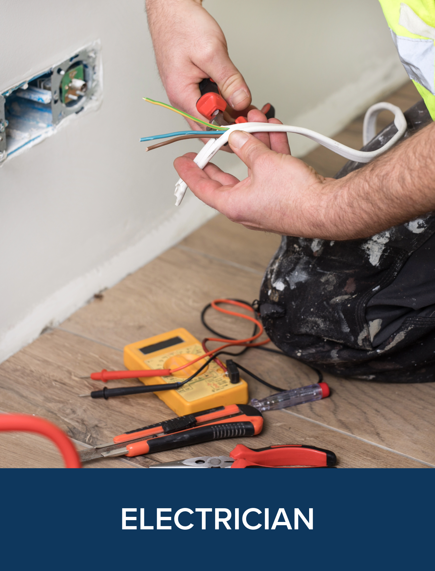 A person working on electrical wiring with tools and a multimeter on the floor.