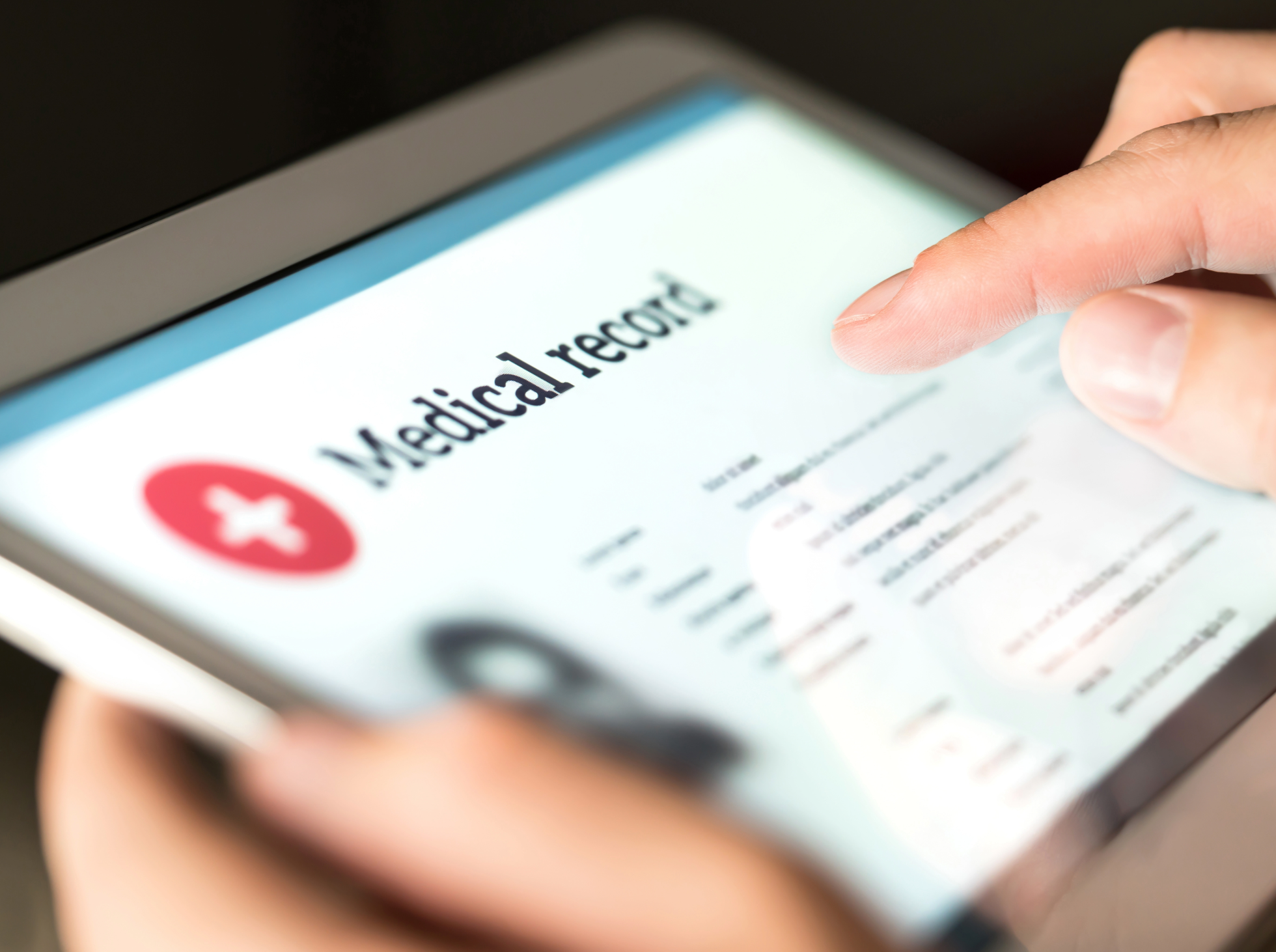 A person is touching a smartphone screen displaying a medical record or health-related app.