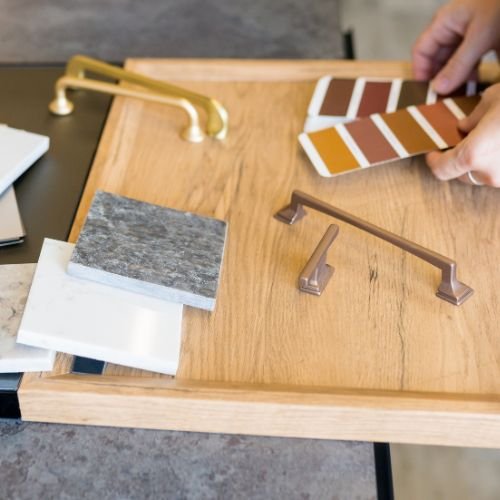 A person testing paint colors and materials for a home renovation or design project