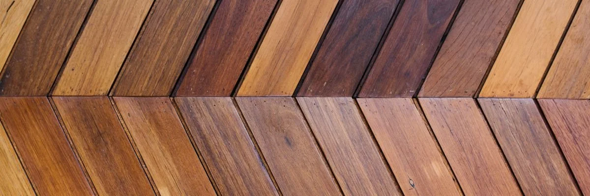 Close-up of wooden planks arranged diagonally, showing different shades of brown and wood grain textures.