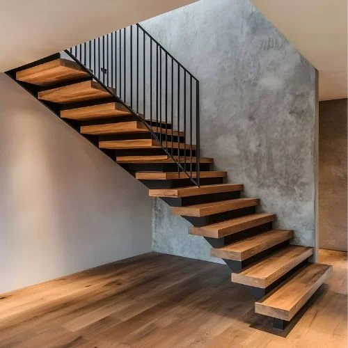 Modern staircase with wooden steps and black metal railing against concrete wall in a minimalist interior.