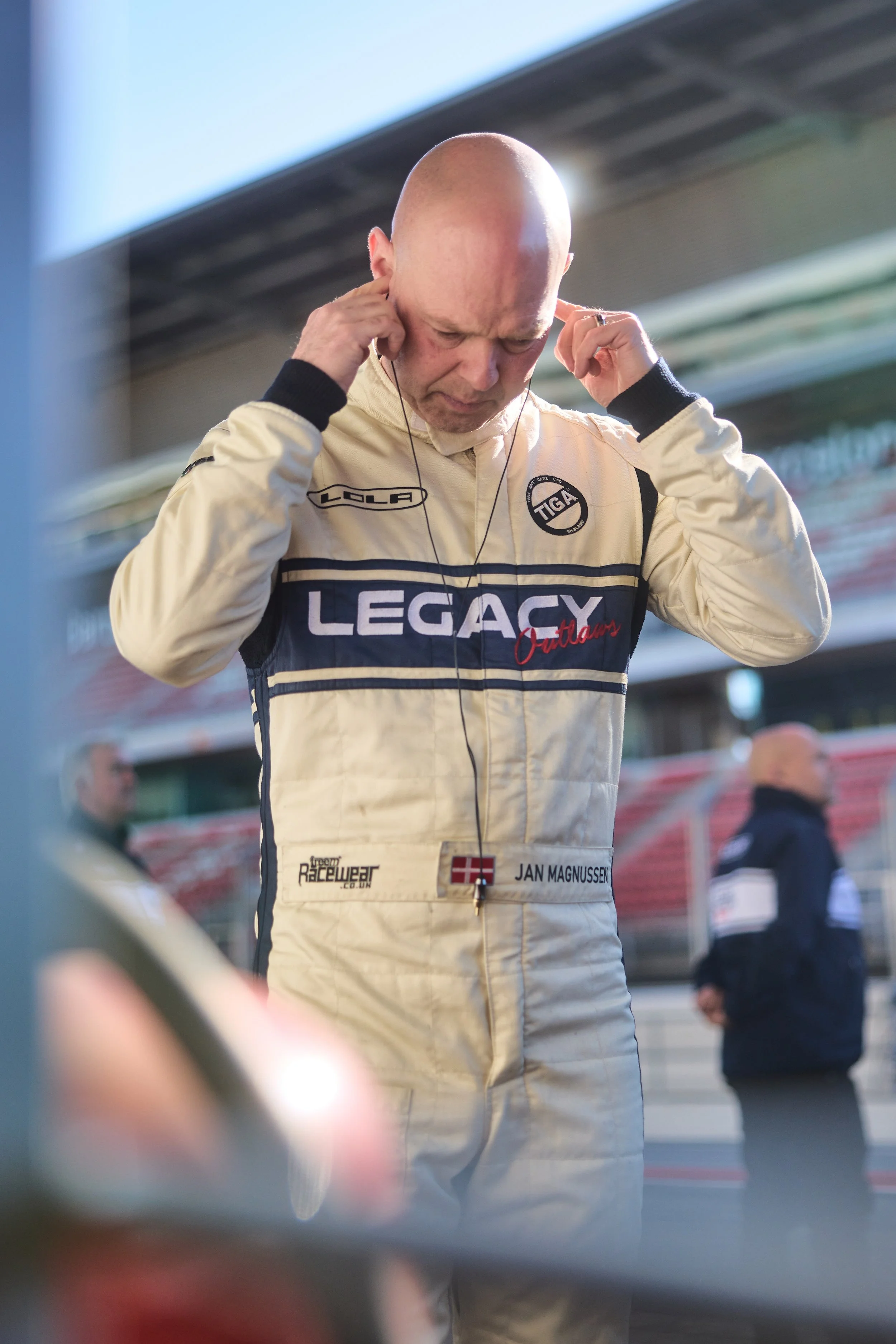 Jan Magnussen. Fitting his earpiece on the pitwall. "JAN MAGNUSSEN" on the suit, Danish flag alongside.