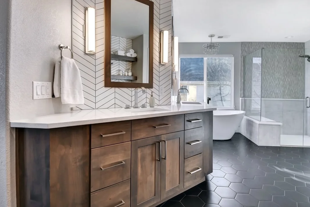Peace out, early-2000s builder grade bathroom complete with giant built-I&rsquo;m tub, tiny shower and dueling vanities. Hello, beautiful with a sleek freestanding tub, layered textures, and contrast done right!
