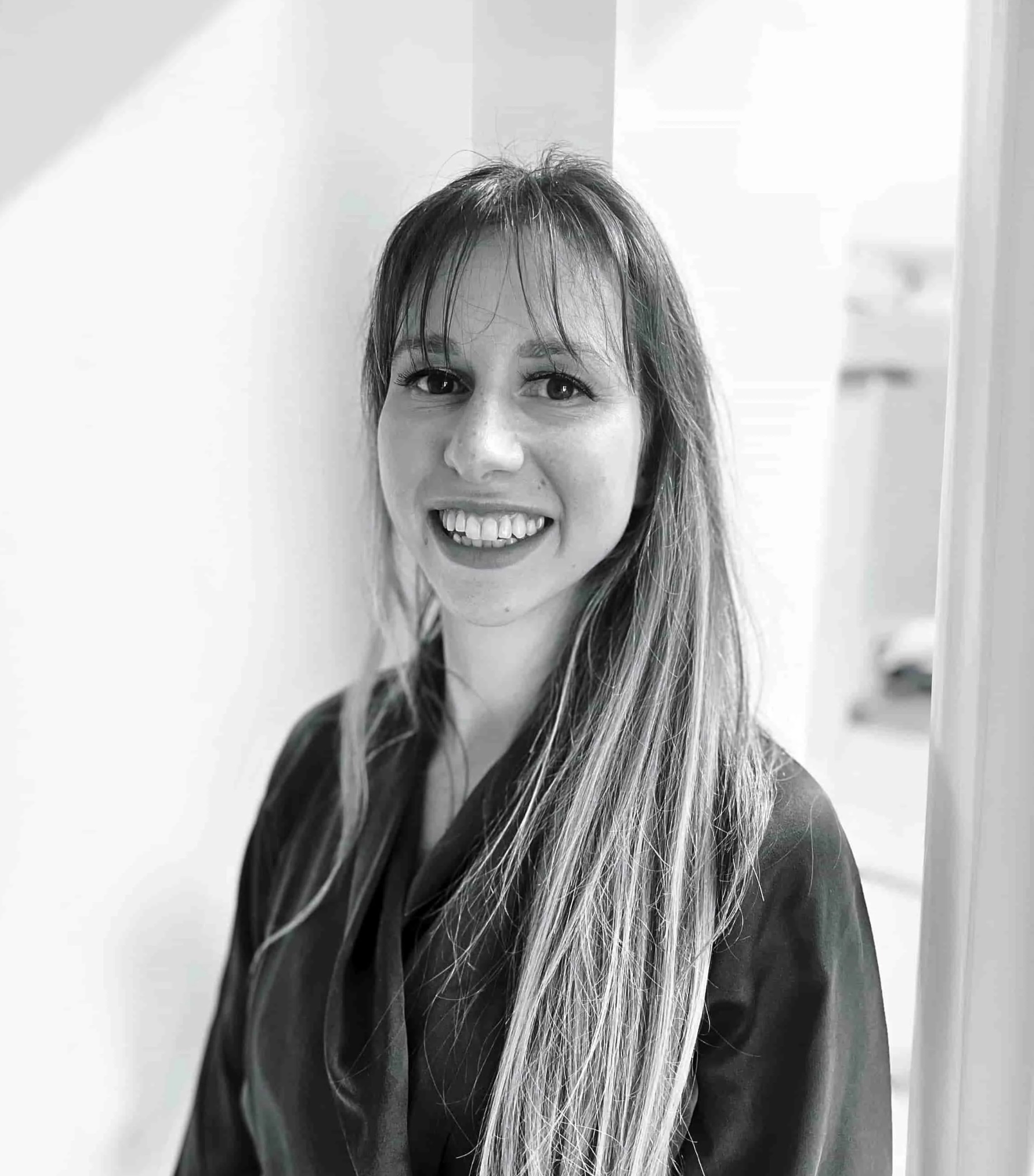 Photo of Dr Lucy Fittton, Chartered Clinical Psychologist, smiling, in black and white.