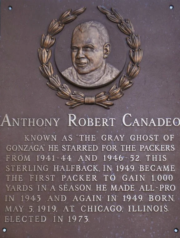 Plaque with a portrait of Anthony Robert Candelo surrounded by a wreath. The plaque contains biographical information about him, mentioning his nickname "The Gray Ghost of Gonzaga," his career as a football player from 1941 to 1952, and that he was born May 5, 1919, in Chicago, Illinois, and elected in 1973.