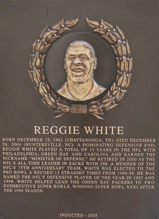 Plaque with a photoshopped image of Reggie White surrounded by a laurel wreath, providing biographical information about his life and football career.