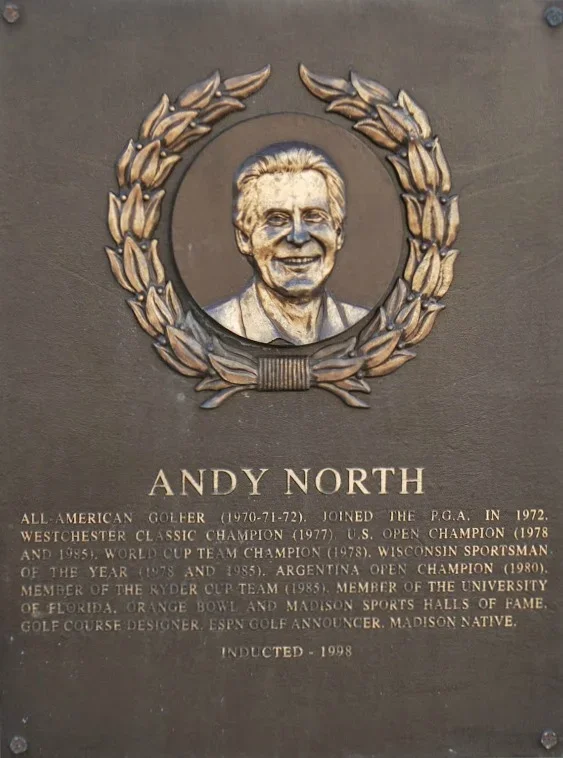Plaque with a portrait of Andy North, surrounded by a laurel wreath, displaying his achievements as a professional golfer and sportsman.