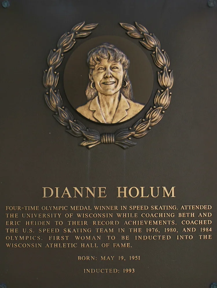 Plaque with a portrait of Dianne Holum surrounded by a laurel wreath, describing her achievements as a four-time Olympic medalist in speed skating, her education at the University of Wisconsin, her coaching career, her induction into the Wisconsin Athletic Hall of Fame in 1993, her birth date, and her induction year.