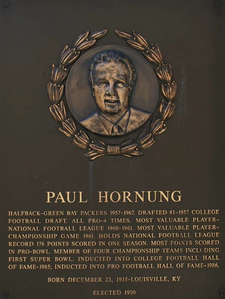 Plaque with a portrait of Paul Hornung surrounded by a laurel wreath. Text details his career as a football player, including teams, records, awards, and date of birth and election year.
