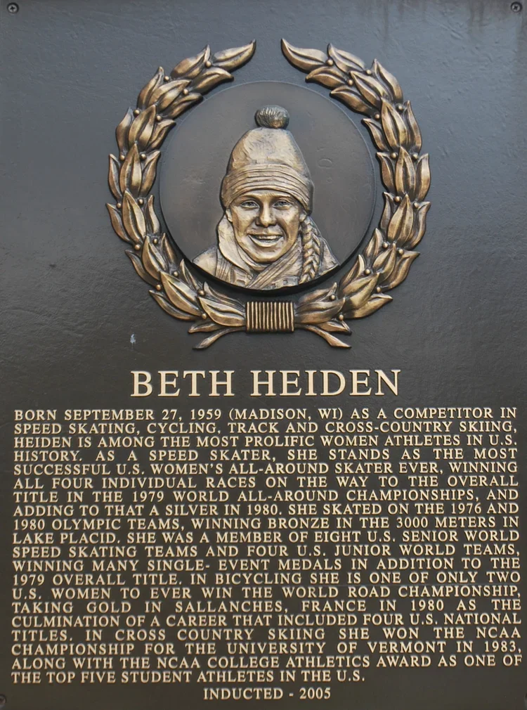 Bronze plaque with a portrait of Beth Heiden surrounded by a laurel wreath, and a detailed biography text underneath.