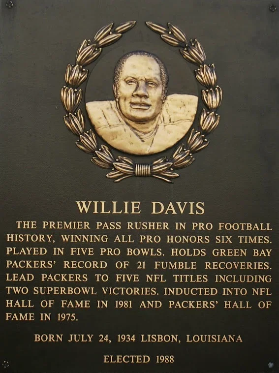 Plaque with a portrait of Willie Davis surrounded by a laurel wreath, describing his football achievements, birth date, and election year.