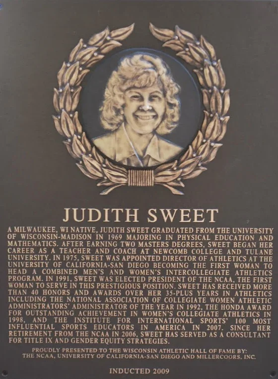 Plaque with a portrait of Judith Sweet surrounded by a laurel wreath, describing her achievements and honors in athletics and education.