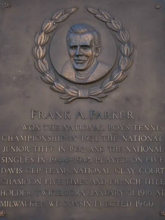 Plaque with a portrait of Frank A. Parker surrounded by a laurel wreath, detailing his achievements in tennis, including national championships and titles, and his birth date and place.