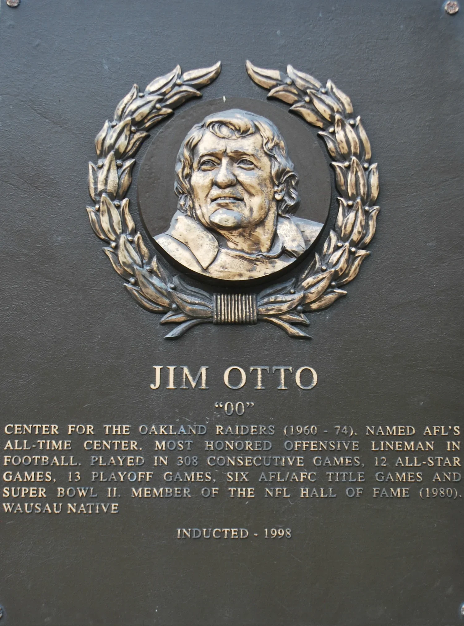 Plaque honoring Jim Otto, former Oakland Raiders football player, with a portrait of him surrounded by a wreath. The plaque includes details about his career and honors.