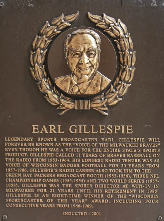 Plaque with a portrait of Earl Gillespie, surrounded by a wreath, and information about his career as a sports broadcaster and athlete.