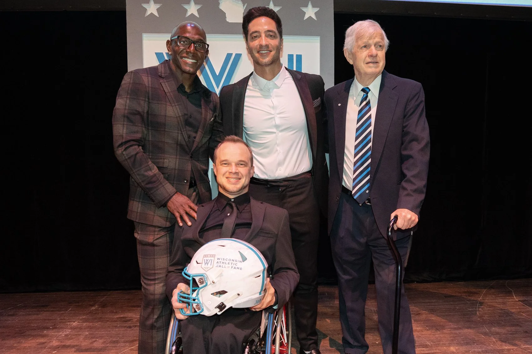 Donald Driver, Ryan Braun, Bob Gansler, and Bohn Boie pose for a photo on stage for the 2026 Wisconsin Athletic Hall of Fame Induction Ceremony