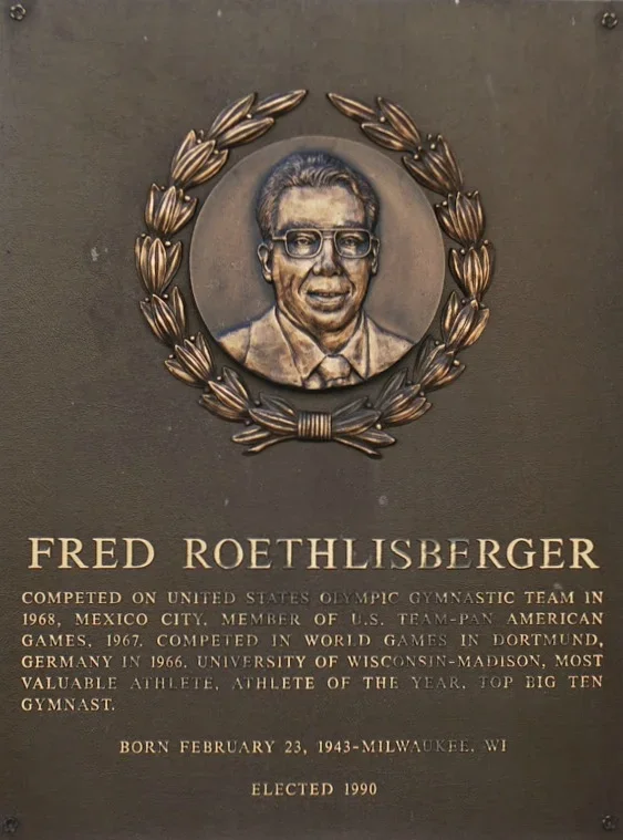 Plaque honoring Fred Roethlisberger, featuring a portrait, laurel wreath, and text about his athletic achievements, birth date, and election year.