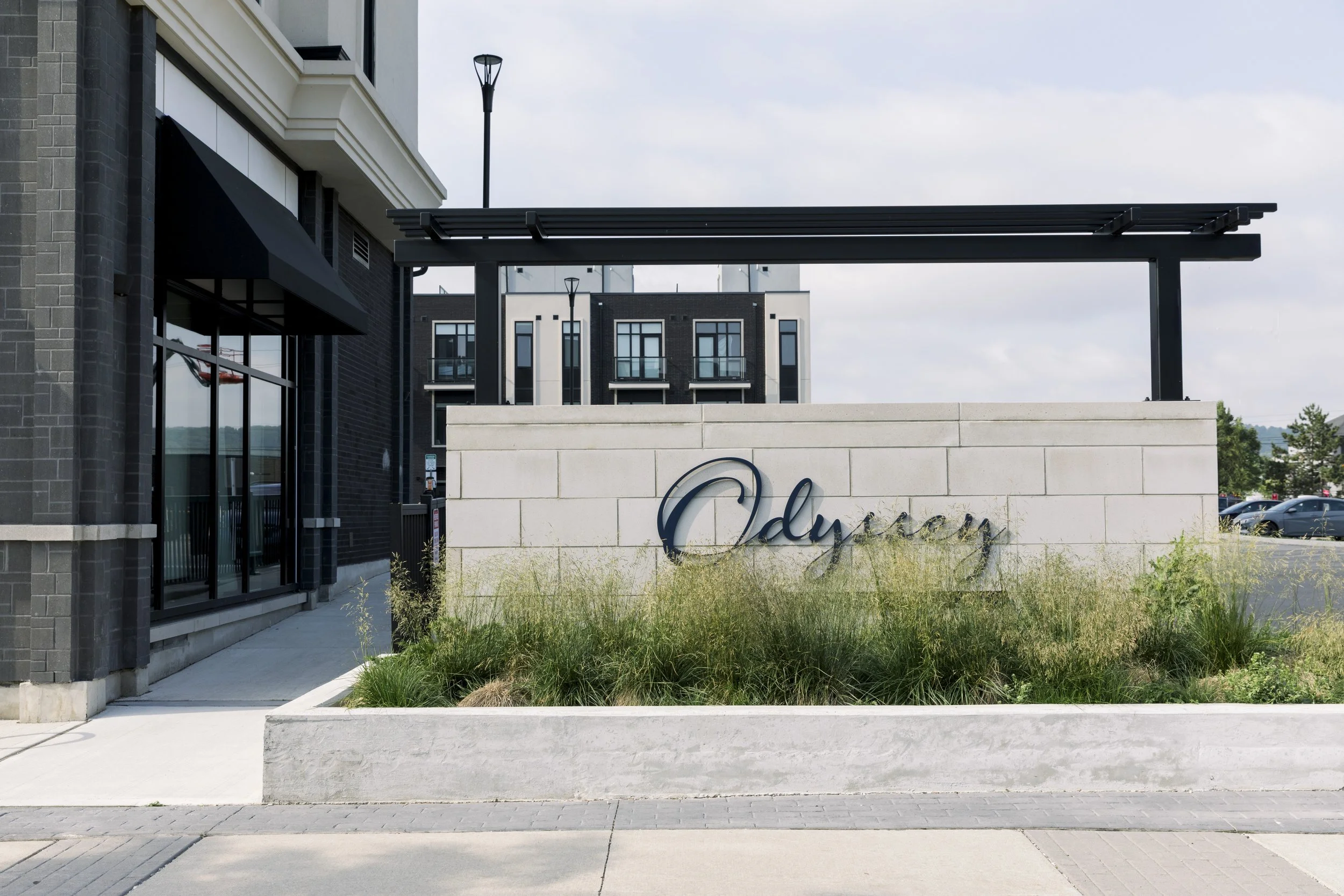 Street view of a modern building with a white wall sign reading Odyssey