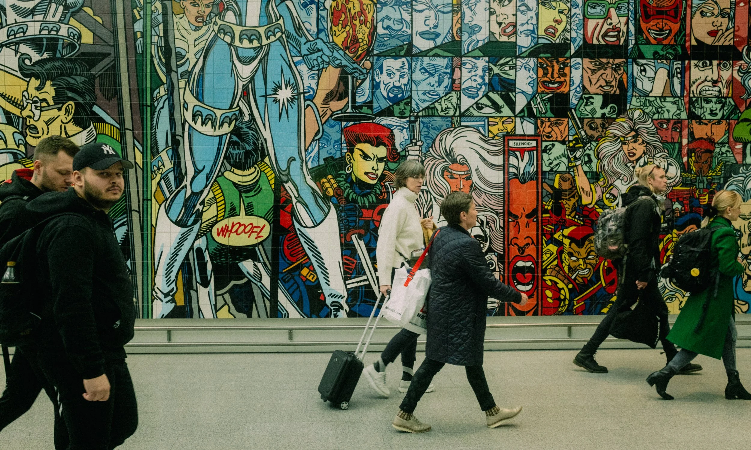 Iceland A colorful comic-style mural featuring various superheroes with a group of people walking in front of it. Virginia Travel Photographer. 