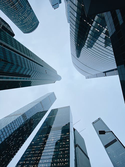 looking up at tall modern skyscrapers with glass facades in a city skyline