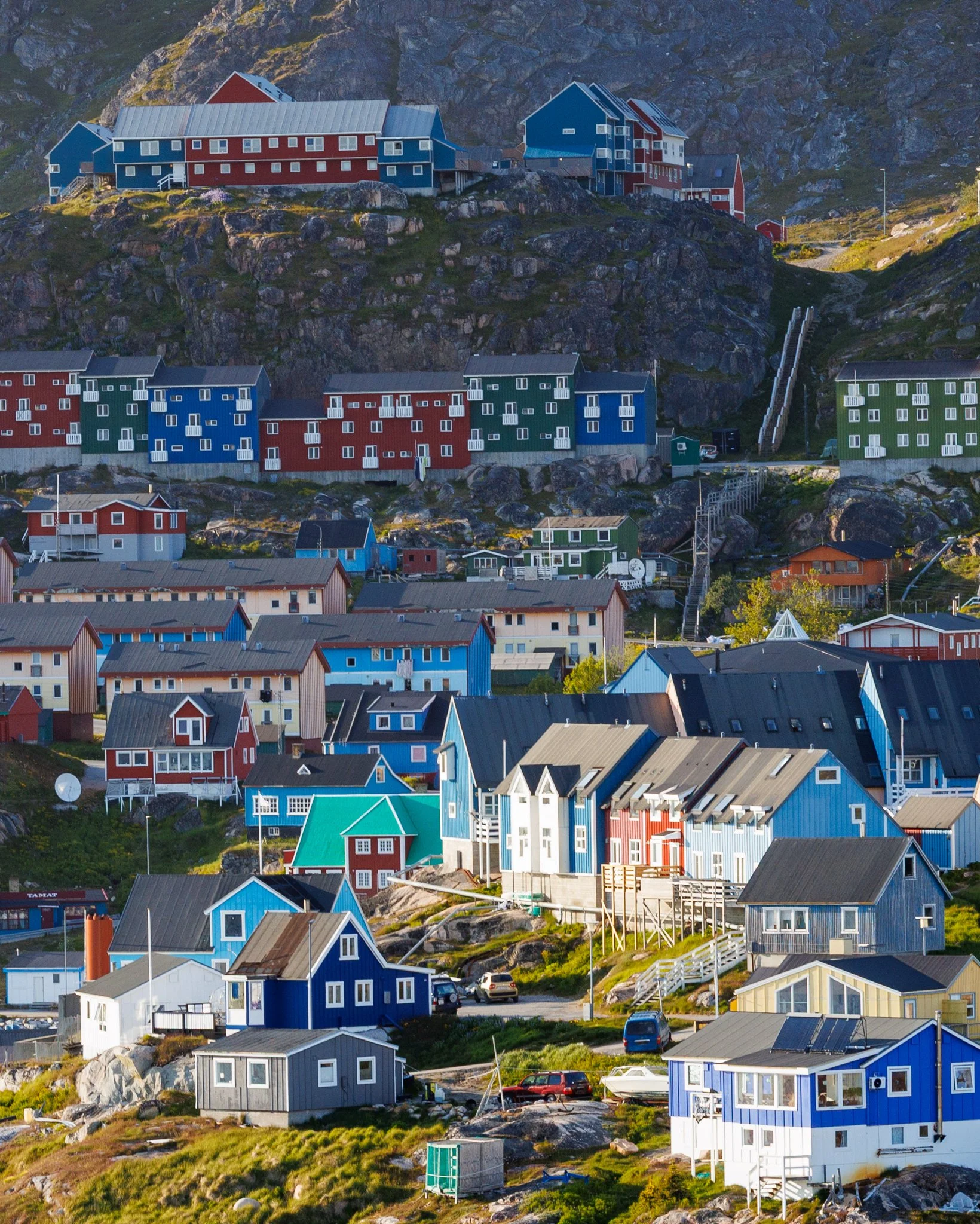 Kolorowe domki to nie tylko estetyka, ale też praktyczne rozwiązanie — w surowym, arktycznym krajobrazie ułatwiają orientację i od wieków pomagają odróżniać funkcje budynków, np. czerwony dla handlu, żółty dla instytucji czy niebieski dla rybołówstwa