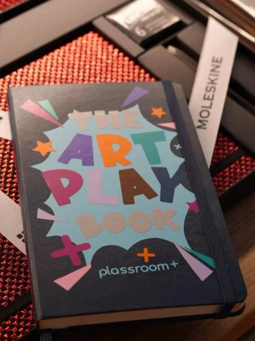Cover of a colorful art activity book titled 'The Art Play Book' with playful letters and star shapes, published by Classroom+.