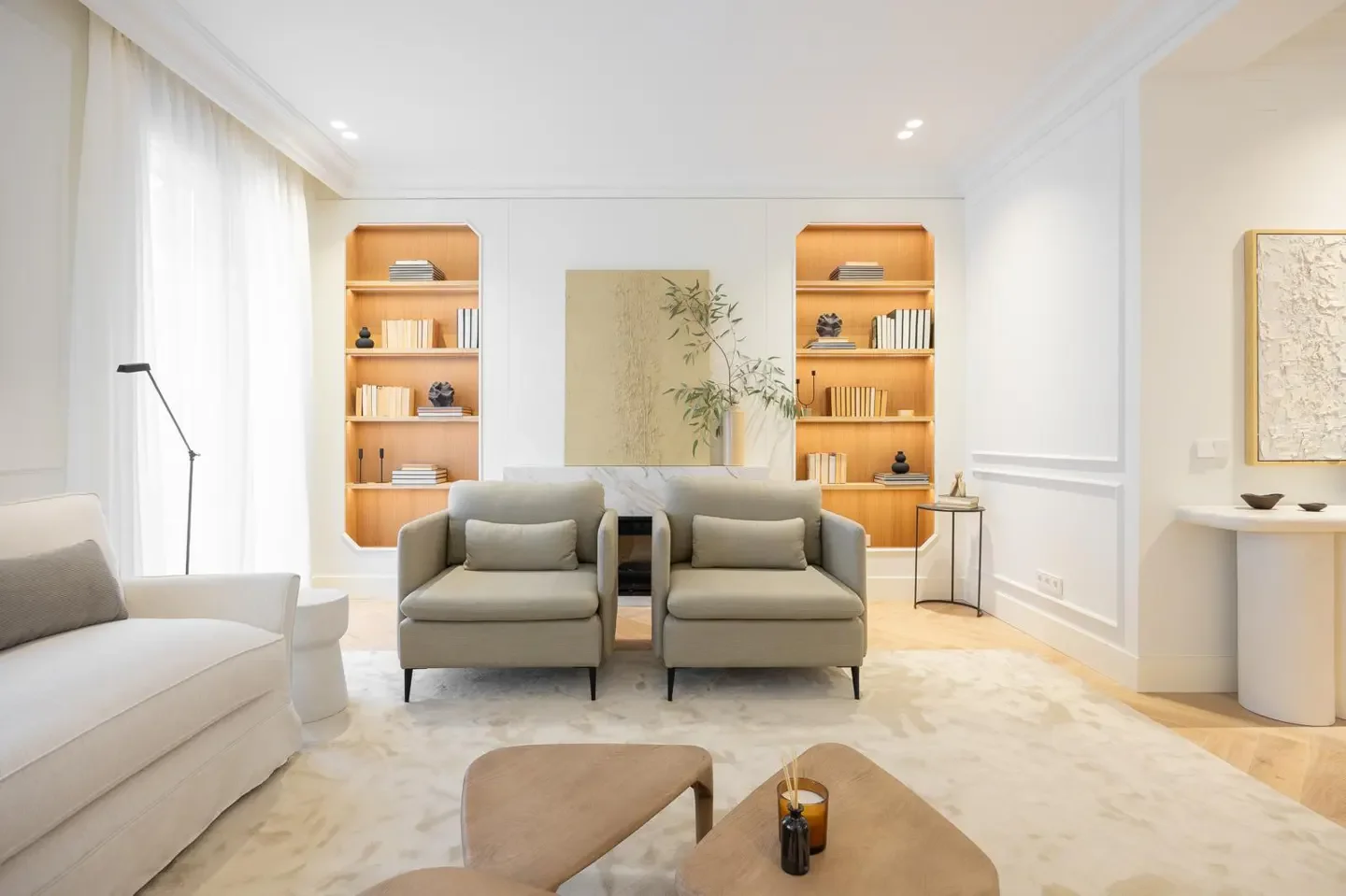 Modern living room with white walls, built-in bookshelves, and comfortable seating.