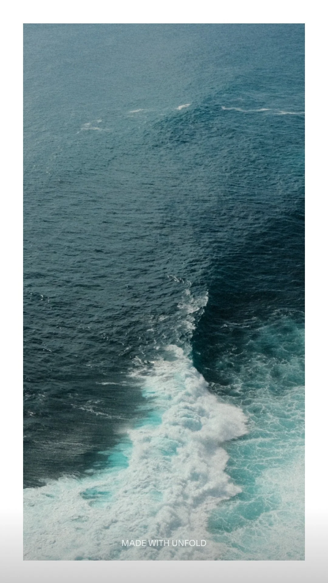View of the ocean with boat wake trail in blue water