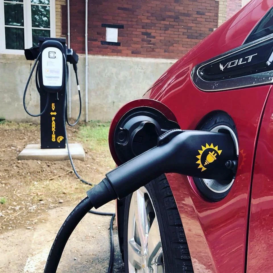 red electric vehicle being charged at a donated charging station