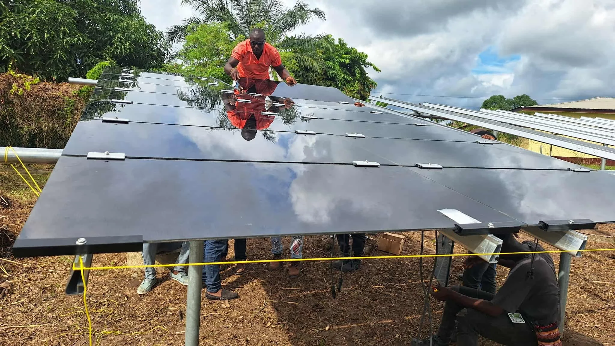 Man installs a ground-mounted solar panel in Africa