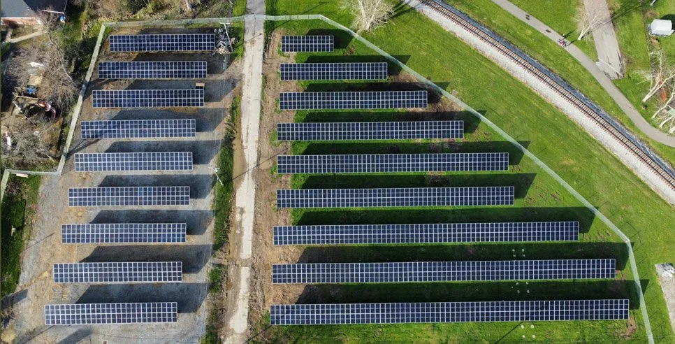 bird's eye view of a ground-mount solar system on a green field