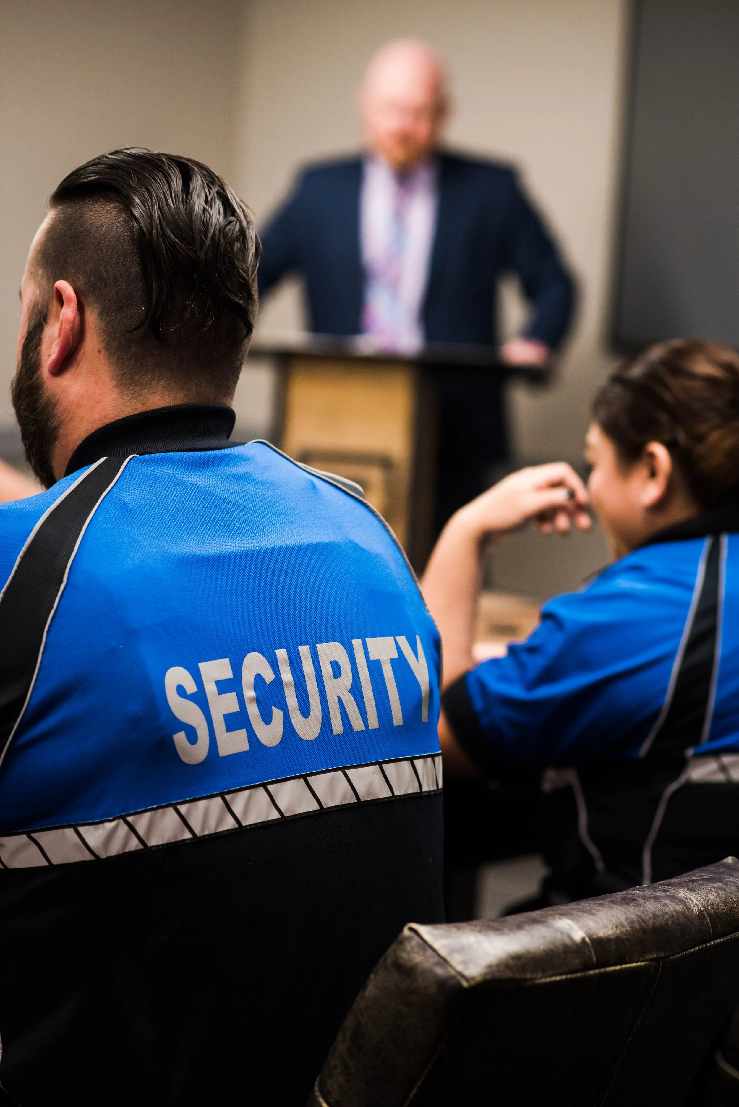 Security personnel attending a presentation or training session in a conference room.