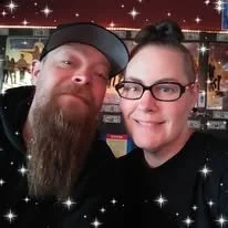 A couple smiling for a selfie in a decorated indoor setting with star embellishments.