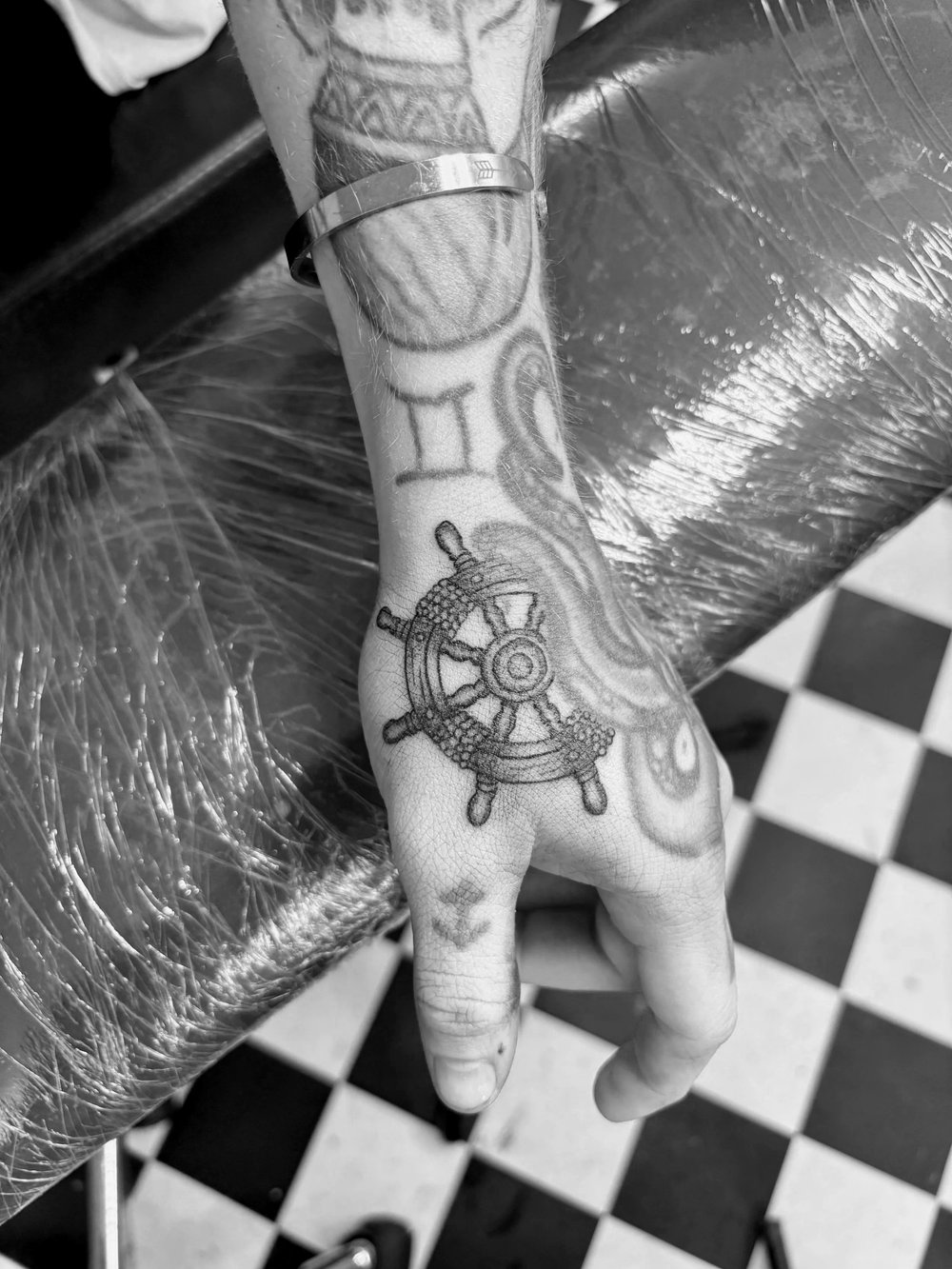 Ships wheel tattoo on a forearm