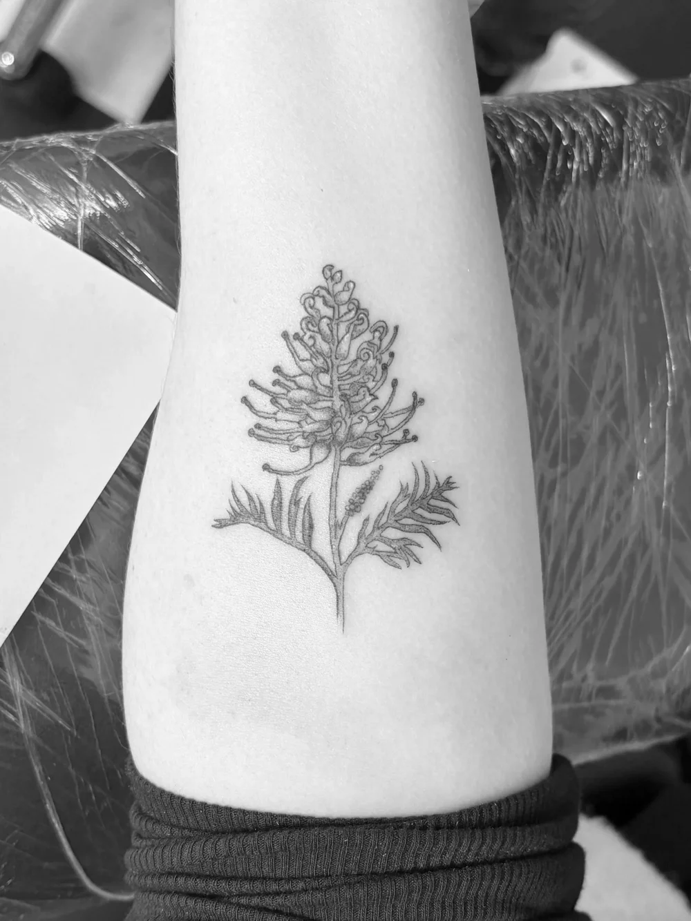 Fine line botanical tattoo on a thigh