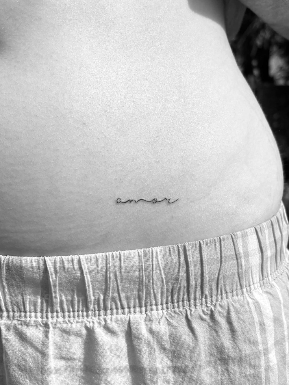 Fine line amor lettering on a hip