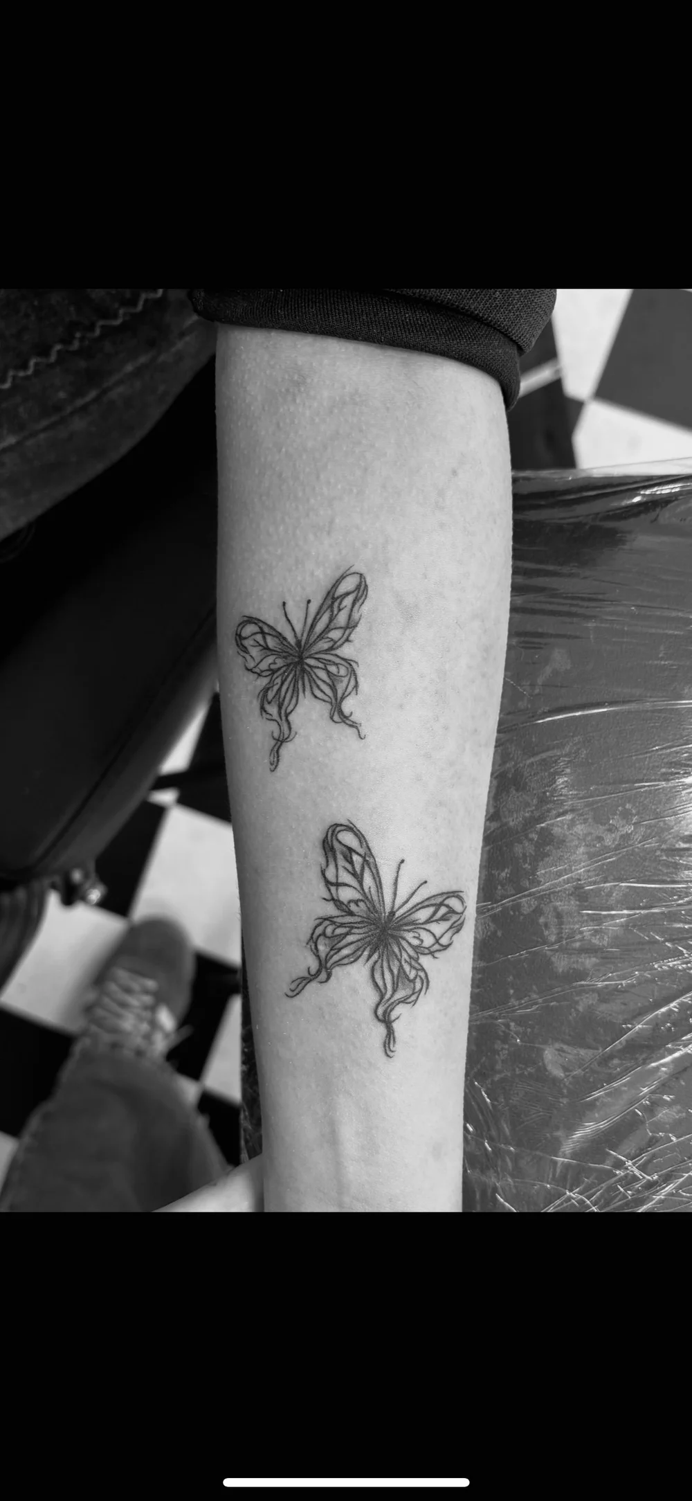 Two butterflies tattooed on a forearm
