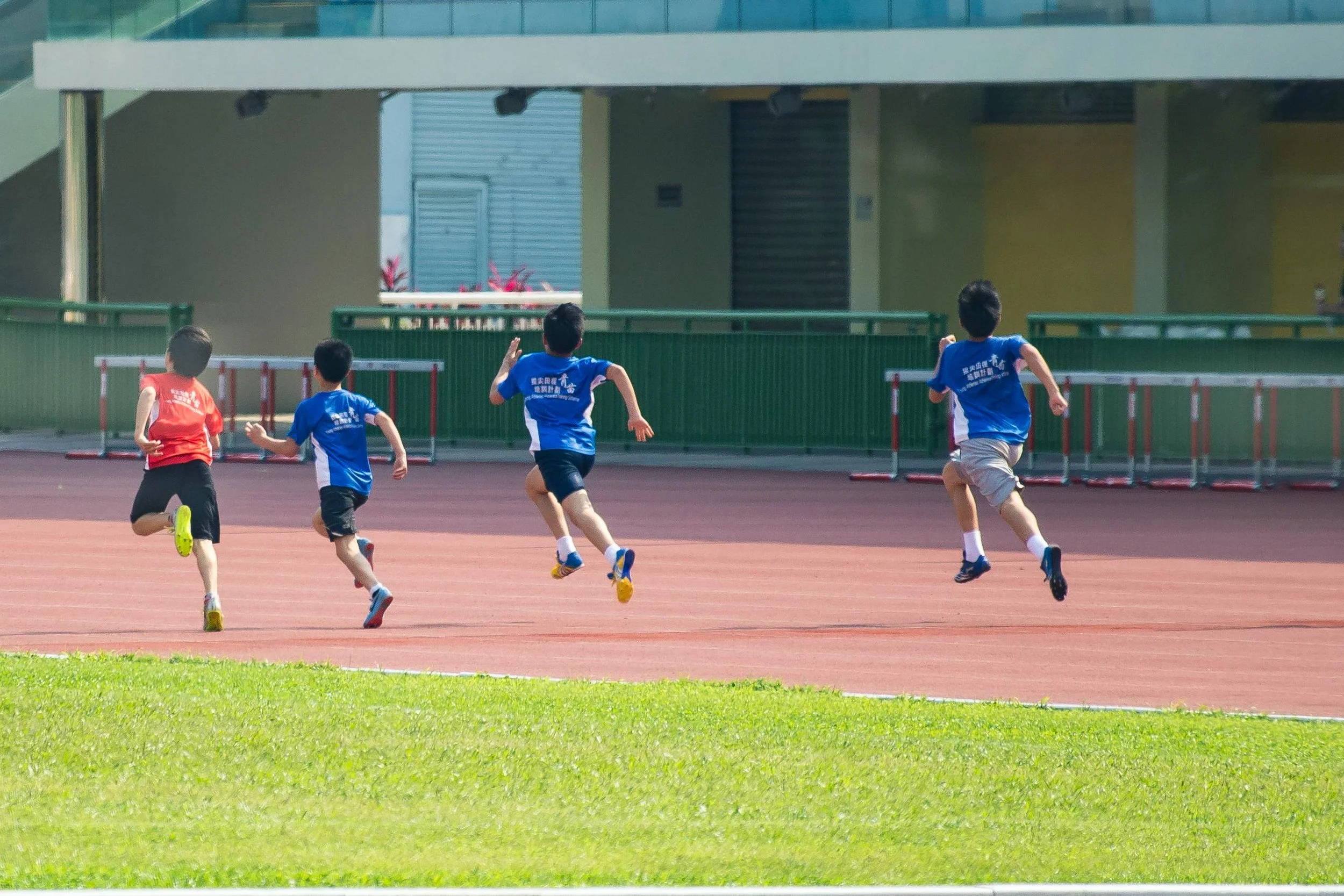 Children running on a track during a sports activity.