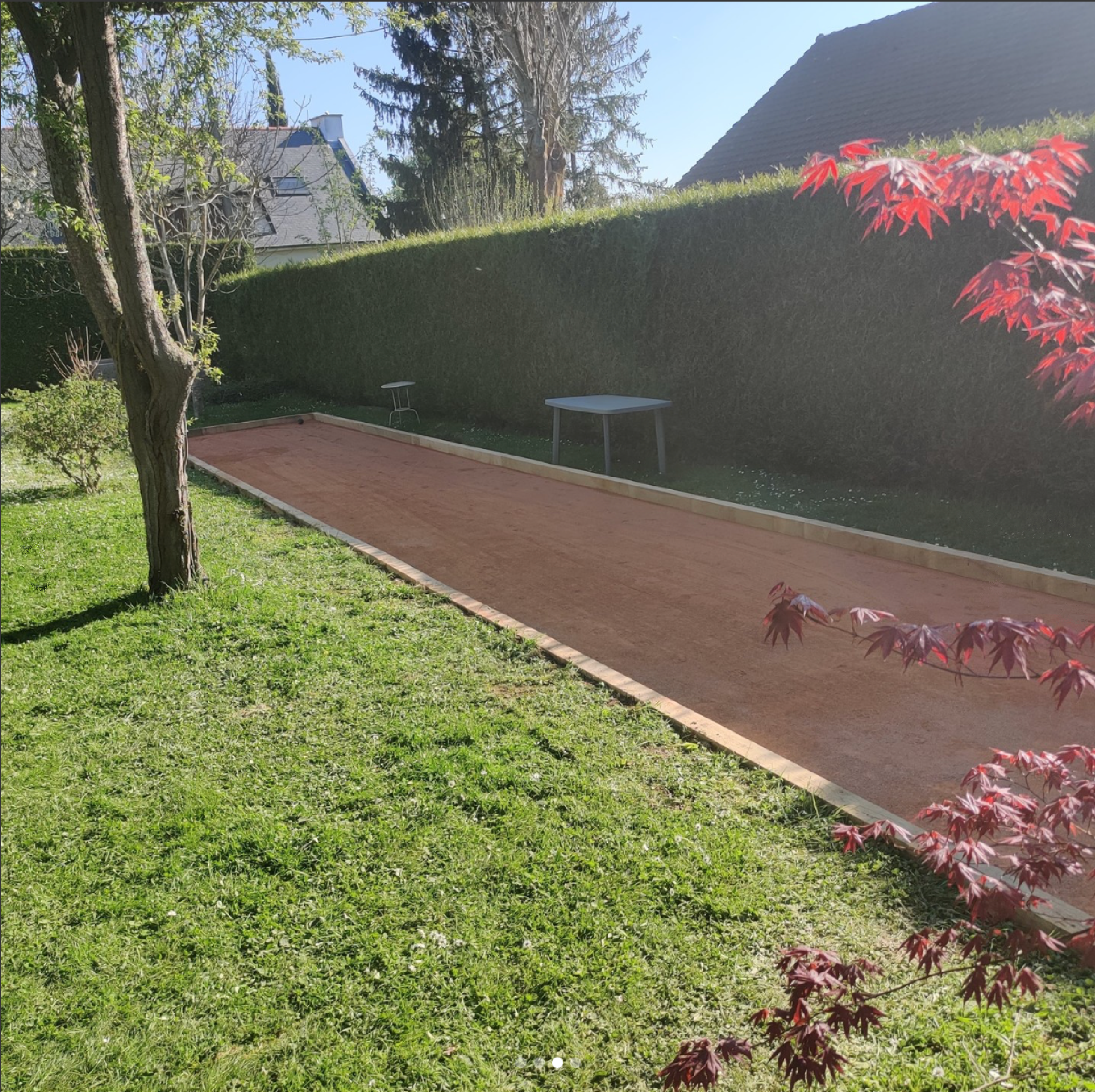 Terrain de pétanque réalisé par ATP avec arbre et jardin