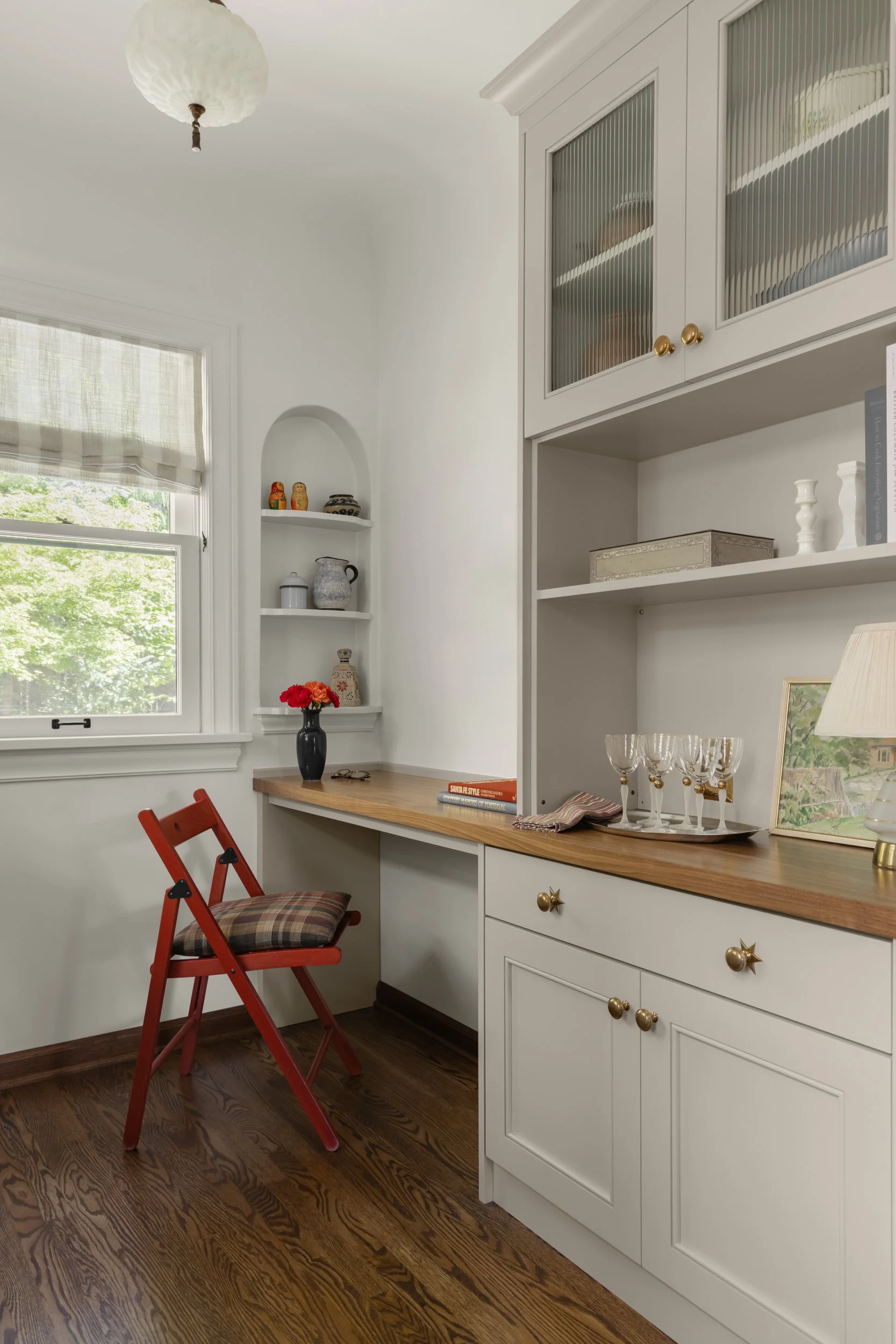 Custom office nook featuring built-in shelving, warm wood countertops, fluted glass cabinetry, and a dedicated workstation by Full Bloom Interior Design in Seattle.