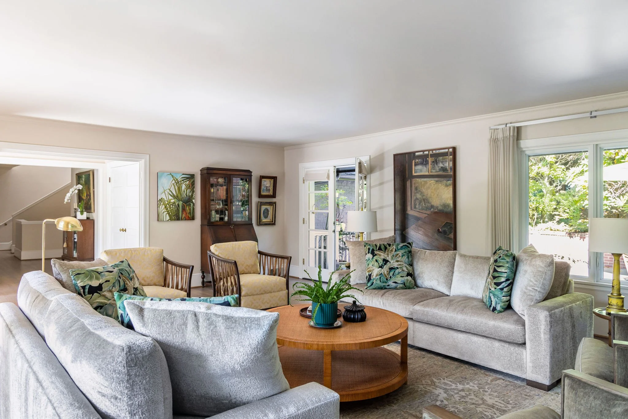 Tropical living room featuring cream sofas, bamboo armchairs, a round cane coffee table and decor by Full Bloom Interior Design in Seattle.