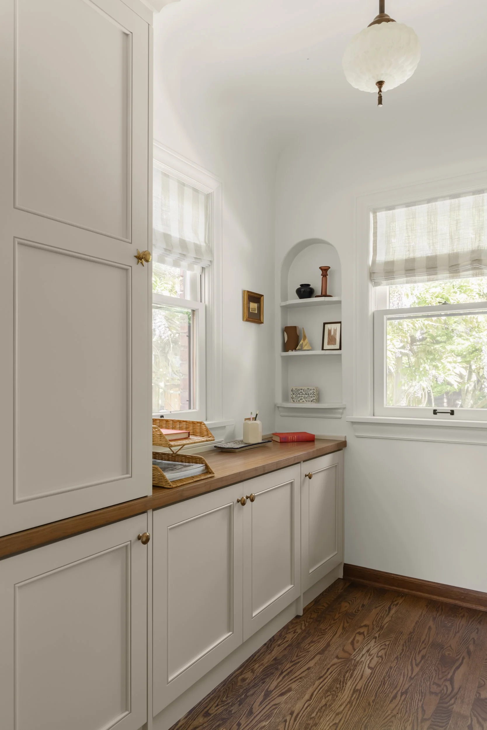 Detailed view of a custom office nook with warm wood countertops and custom cabinetry.