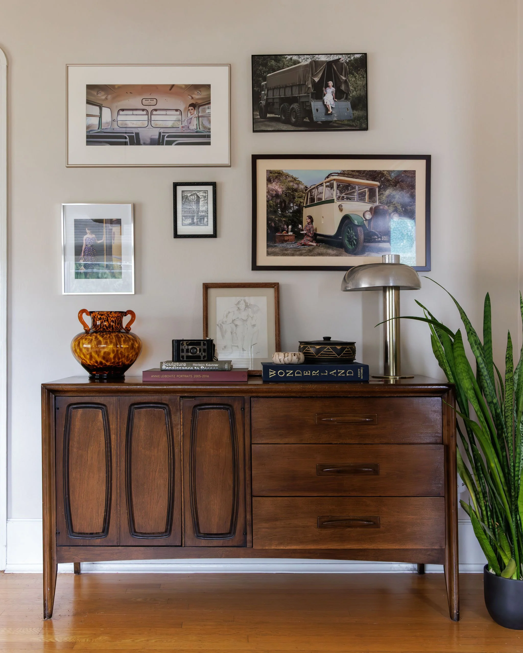  Mid-century modern walnut console table with framed wall art above and decor on top by Full Bloom Interior Design in Seattle.